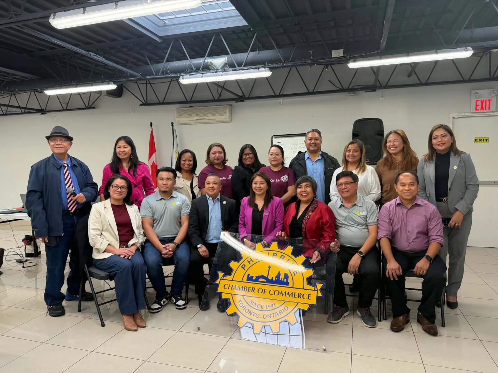 The newly elected PCCT board, seated and standing behind the chamber seal, with the election officers at the Filipino Centre Toronto.